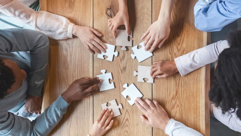 Team von Mitarbeitenden bei einer gemeinsamen Aktivität außerhalb des Büros, die Kreativität, Zusammenarbeit und den Austausch neuer Ideen fördert.