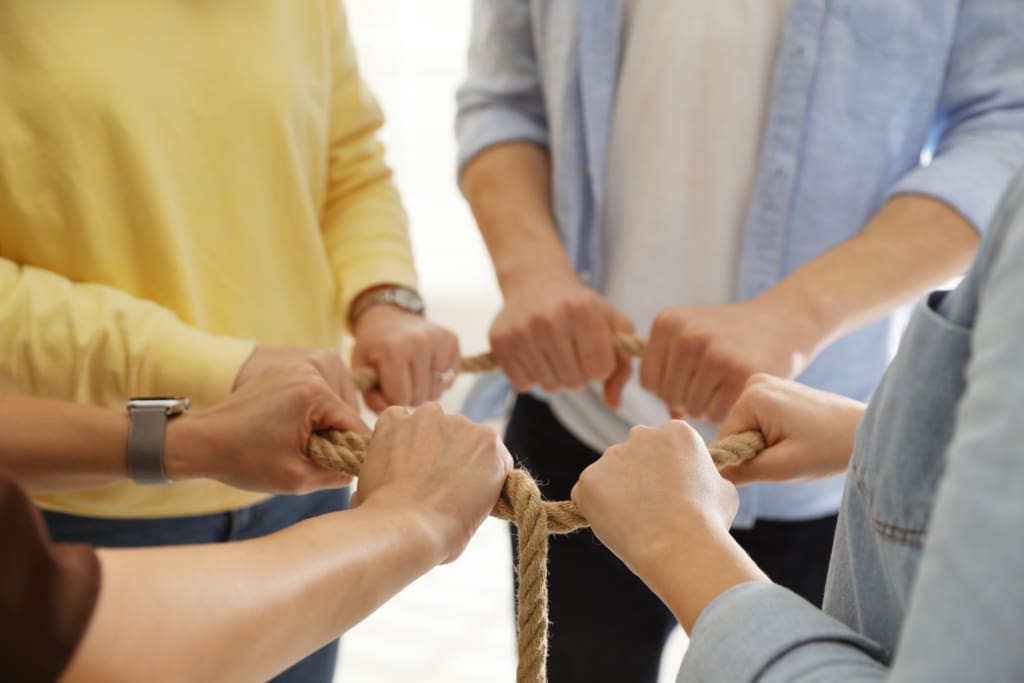 Produktivität und Burnout im Team – Mitarbeitende diskutieren während eines Teambuilding-Events über Zusammenarbeit und Kommunikation